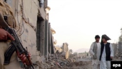 A private security guard at the scene of car bombing in Kandahar. Are the government's forces ready to step in?