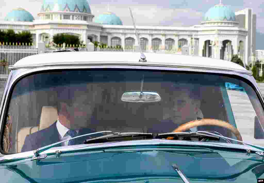 Turkmen President Gurbanguly Berdymukhammedov (right) and Russian Prime Minister Dmitry Medvedev ride in a GAZ-21 Volga car during a meeting in Ashgabat on May 31. (AFP)