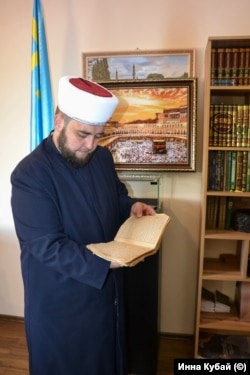 Мурат Сюлейманов разгръща един от древните преписи на Корана.