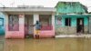 Dominican Republic - A man stands next to a house on a flooded street after the passing of the tropical storm Melissa before becoming a hurricane at Las Cucarachas neighborhood in Santo Domingo, Dominican Republic on October 28, 2025. 