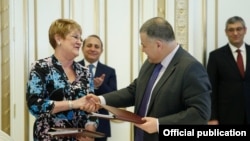 Armenia - The chief of the Armenian government staff, Davit Harutiunian (R), and Karen Hilliard, the USAID’s mission director for Armenia, sign an agreement in Yerevan, 5Feb2016.