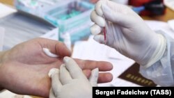 Медработник производит забор образца крови у пациента. Иллюстративное фото.