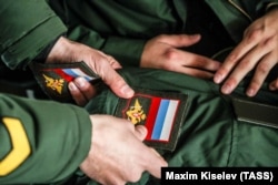 Kemerovo, Oroszország, 2021. október 21. A sorkötelesek karjelzést erősítenek fel a katonai egyenruhára egy sorozási irodában a szibériai Kemerovo városában a 2021-es őszi katonai behívókampány során