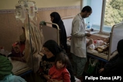 A doctor checks on a patient as others sit in a crowded room at Indira Gandhi Children's Hospital in Kabul on October 5.