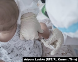 A child named Dima receives an insulin shot.