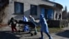 Egészségügyi dolgozók viszik egy Covidban meghalt beteg holttestét az ukrajnai Kramatorszk hullaházába 2021. október 30-án