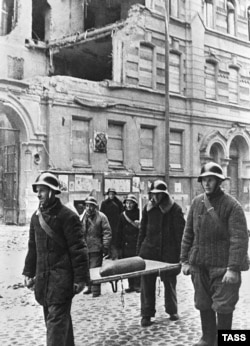 Ленинград, ноябрь 1941 года. Бойцы противовоздушной обороны несут неразорвавшийся немецкий снаряд