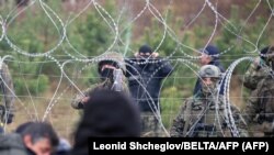 Militari polonezi blochează trecerea graniței din Belarus pentru sute de migranți ilegali, 8 noiembrie 2021. 