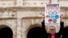 Un demonstrant ține o pancartă cu boicotarea Jocurilor Olimpice de iarnă de la Beijing 2022, cu o zi înainte de summitul G20 de la Roma. 29 octombrie 2021.