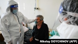 Egy orvos vizsgál egy beteget egy bolgár kórház Covid–19-osztályán, Kjusztendilben 2021. október 19-én, Bulgária sötétvörös Covid-zónájának egyik településén, ahol százezerből több mint ötszáz ember fertőződött meg koronavírussal