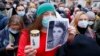 Жена държи портрет на Изабела и свещ на протест във Варшава на 6 ноември