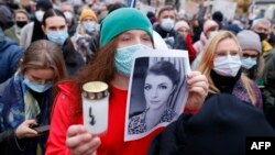 Жена държи портрет на Изабела и свещ на протест във Варшава на 6 ноември