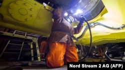 A photo taken on September 9 shows a specialist welding a pipe during the final stage of the Nord Stream 2 pipeline construction in the Baltic Sea.