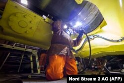 Egy szakember csövet hegeszt az Északi Áramlat 2 gázvezeték építésének utolsó szakaszában a Fortuna nevű hajó fedélzetén a Balti-tengeren 2021. szeptember 9-én