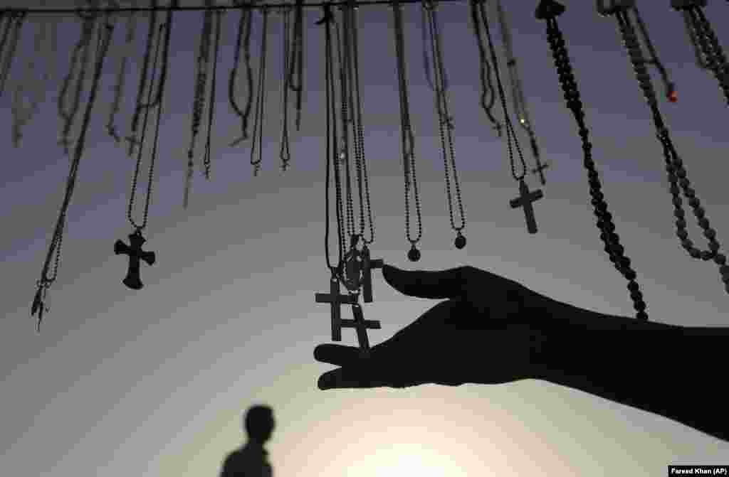 A vendor displays variety of cross necklaces outside a graveyard where Christian families were visiting on All Souls&#39; Day in Karachi, Pakistan, on November 2.