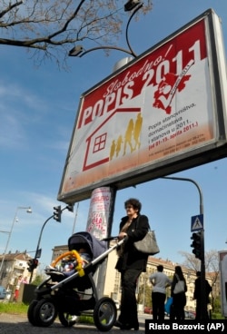 A woman walks past a billboard reading "Free Census 2011" in downtown Podgorica, Montenegro, in April 2011.