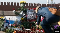 Женщина оставляет цветы на месте убийства российского оппозиционного политика Бориса Немцова. Москва, 9 марта 2015 года.