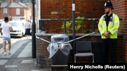 A police officer guards a cordoned off rubbish bin on Rolleston Street in Salisbury, England, on July 5 after it was confirmed that two new people had been poisoned with the nerve agent Novichok.