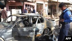 The wreckage of a car at the site of a car bomb Al-Hamdaniya in March