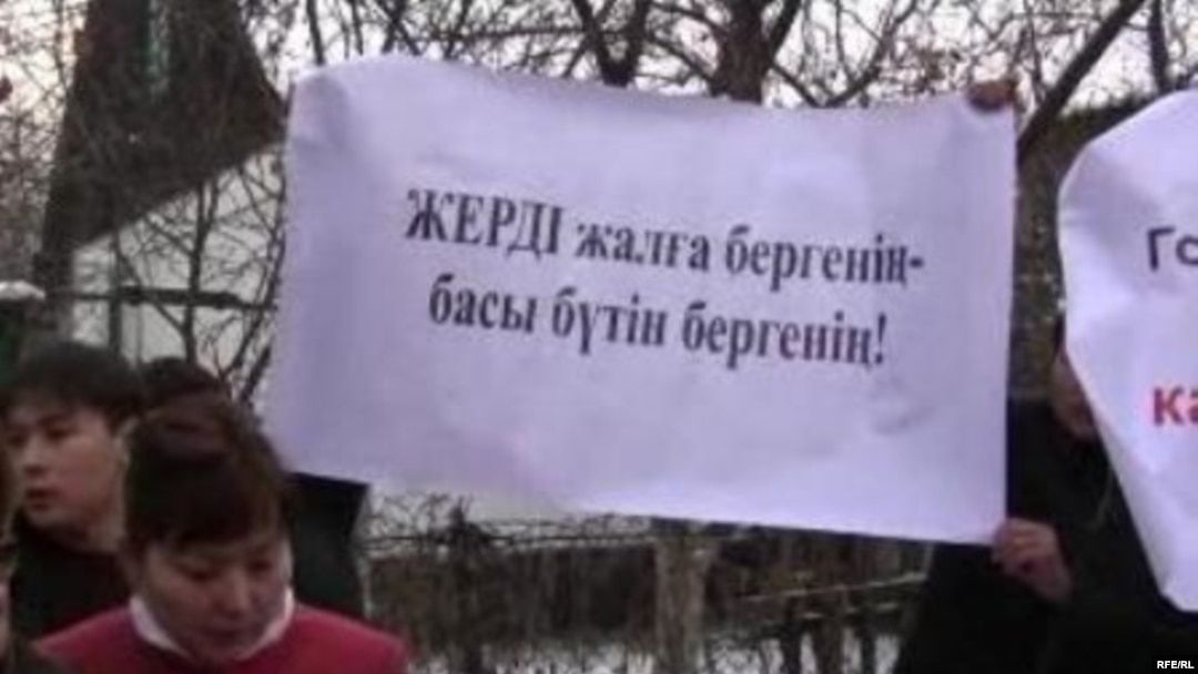 Kazakh activists near the Chinese Embassy in Almaty hold a poster with the words: “To give land for rent means to give forever."