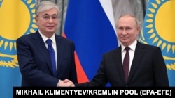 Kazakh President Qasym-Zhomart Toqaev (left) and Russian President Vladimir Putin shake hands during a joint news conference following their talks at the Kremlin in Moscow on February 10, 2022, two weeks before Moscow's full-scale invasion of Ukraine.