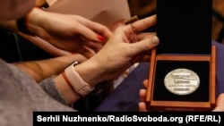 Пам’ятна медаль Олександри Байнак у руках її правнучки Анастасії