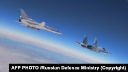Ресей мен Беларусь қарулы күштерінің бірлескен жаттығуы кезінде ұшып бара жатқан ресейлік Ту-22М3 бомбалаушы ұшағы (сол жақта) мен Су-35 жойғыш ұшағы. Ресей қорғаныс министрлігі 2022 жылғы 9 ақпанда таратқан видеосынан скриншот.