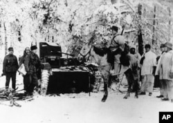 Finnish troops capture a Russian tank in a snow-covered forest on the Eastern Front in January 1940. The Russians lost more than 300 tanks in the first month of the Winter War. Eight years later, the two nations would sign the Soviet–Finnish Treaty of Friendship, Cooperation, and Mutual Assistance.
