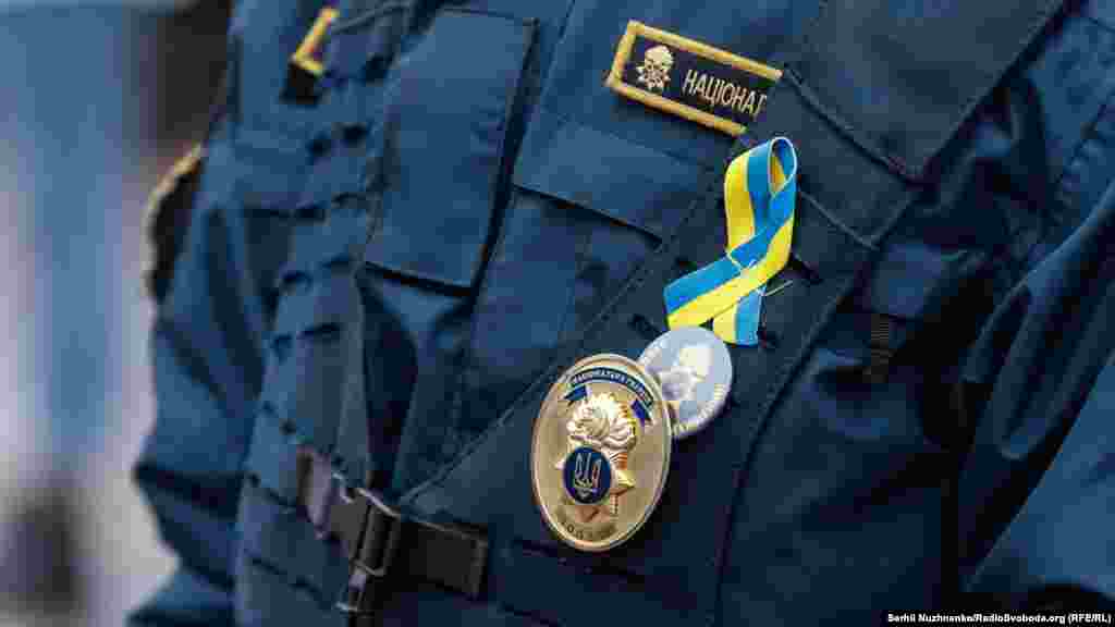 Поліцейський зі стрічкою у кольорах державного прапора України. День єдності у Києві,16 лютого 2022 року
