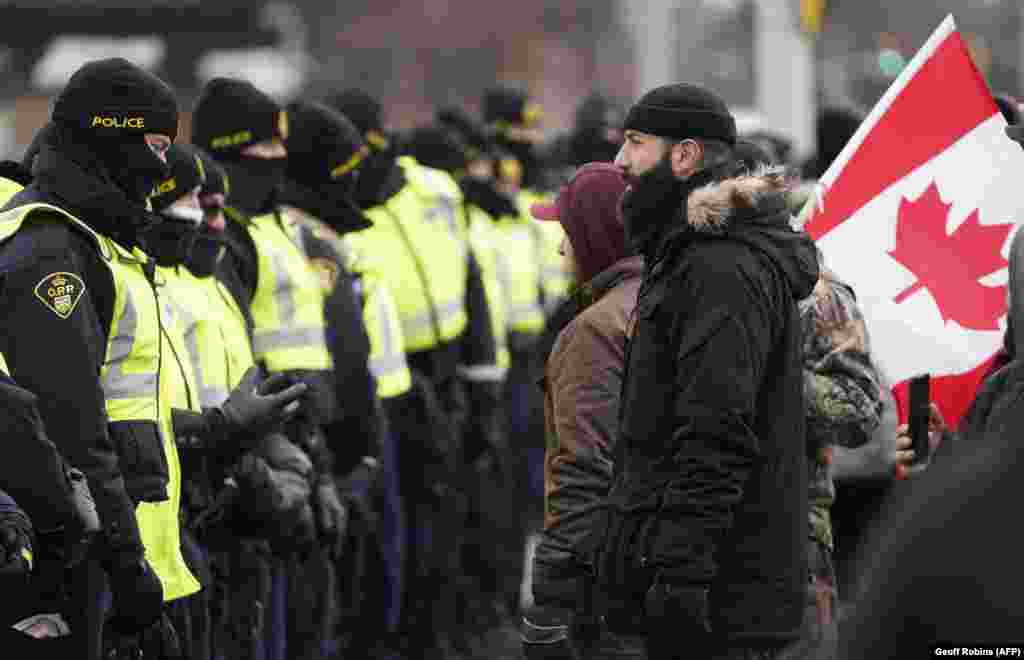 Протестувальники проти обмежень, пов&#39;язаних із коронавірусною хворобою, стоять перед кордоном канадських поліцейських. Віндзор, Онтаріо. Канада. 12 лютого 2022 року &nbsp;