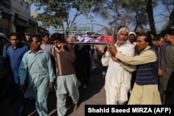 Relatives and locals carry a coffin containing the body of Muhammad Mushtaq for his funeral at Khanewal district on February 13.