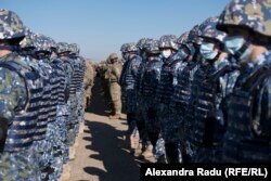 Román és amerikai katonák várakoznak Jens Stoltenberg NATO-főtitkár érkezésére a romániai Mihail Kogălniceanu támaszponton 2022. február 11-én