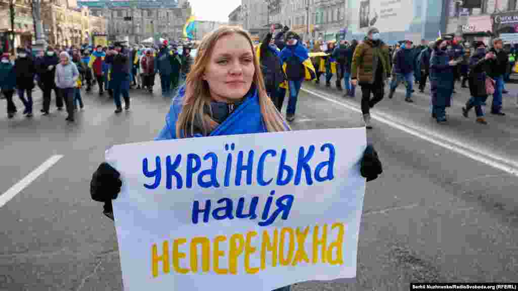 A woman holds a sign that says &#39;The Ukrainian nation is invincible&quot; during a March of Unity in Kyiv against the threat of a new military invasion of Ukraine by Russia.&nbsp;