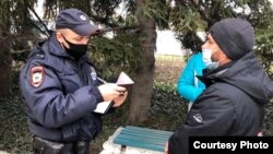 Російський поліцейський переписують дані кримського татарина, який прийшов підтримати затриманих під час обшуків, Севастополь, 9 лютого 2022 року
