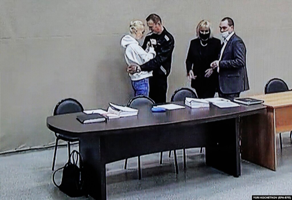 Udhëheqësi i burgosur opozitar rus, Aleksei Navalny (i dyti nga e majta), dhe bashkëshortja e tij, Yulia Navalnaya, shihen në një ekran gjatë një seance dëgjimore në një burg, në rajonin e Vladimirit, në Rusi, më 15 shkurt.