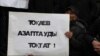 Участник митинга в Алматы с плакатом, призывающим власти Казахстана остановить пытки