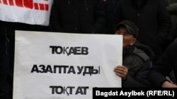 Участник протестной акции держит плакат с призывом к президенту Казахстана остановить пытки. Алматы, 13 февраля 2022 года 