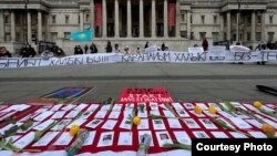 Листы бумаги на площади с именами и фото погибших во время январских событий в Казахстане. Лондон, 13 февраля 2022 года