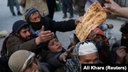 People reach out to receive bread in Kabul.