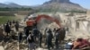 Afghan security forces inspect the site of a blast at a police arms depot in Kandahar on April 21.