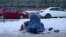 An Afghan woman holding her child begs on a snow-covered sidewalk in Kabul.