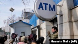 مشتریان یکی از بانک های خصوصی در کابل در بیرون از این بانک صف بسته اند تا از حساب های خود پول برداشت کنند - عکس از آرشیف