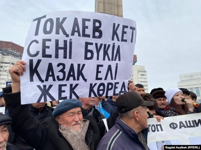 Митингующие держат плакат «Токаев, уходи! Тебя ненавидит вся страна». Алматы, 13 февраля 2022 года