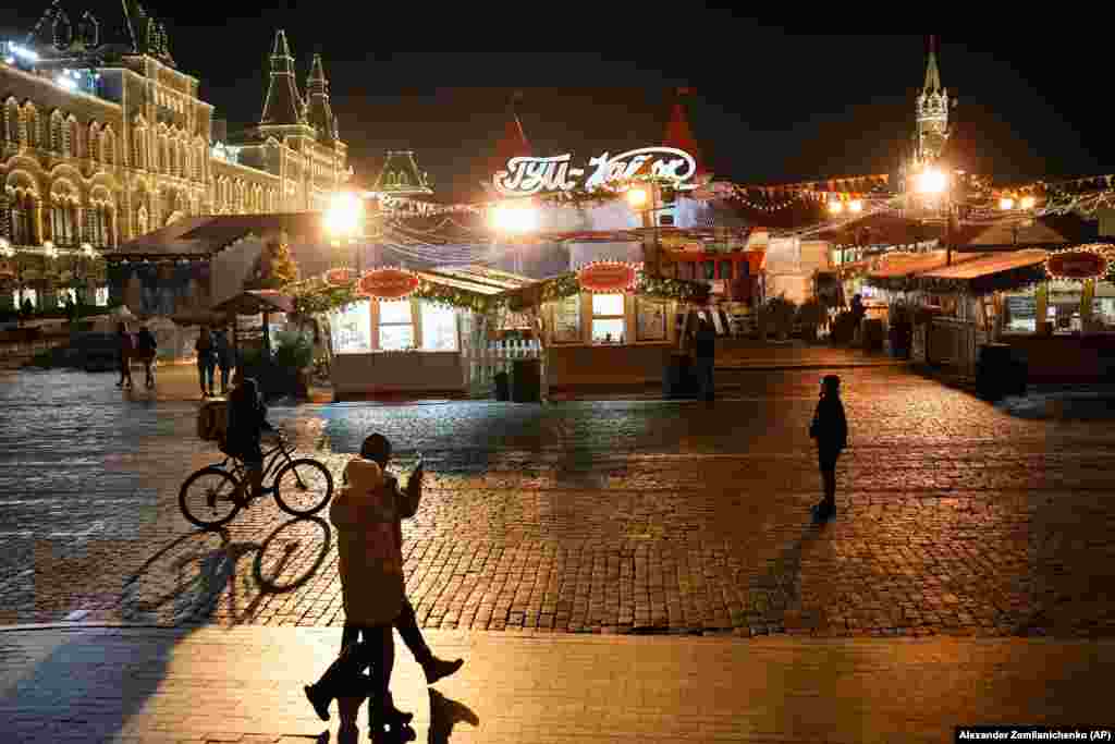 People walk next to a Russian Christmas Market set up on Red Square in Moscow on February 14.&nbsp;