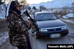 A Taliban fighter stands at a checkpoint near Qargha Lake, a popular weekend destination outside Kabul.