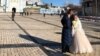Një çift i sapomartuar në sheshin pranë një katedraleje në Kiev më 12 shkurt, 2022. Pavarësisht kërcënimit të një lufte të re me Rusinë, jeta vazhdon normalisht në kryeqytetin e Ukrainës. 