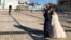 A newly married couple poses for photographs on the square before Kyiv’s St. Michael Cathedral, on February 12, 2022. Despite the looming threat of a new war in Russia, life has continued uninterrupted in the Ukrainian capital. (RFE/Mike Eckel)