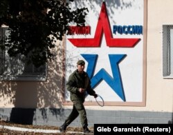 Un soldat rus, surprins în fața grupului operațional al armatei ruse din Tiraspol, Transnistria, 3 noiembrie 2021. Regiunea separatistă aflată la est de Nistru rămâne în continuare ocupată de vechea armată a 14-a a Uniunii Sovietice, în prezent parte din forțele armate ruse.