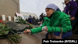 A woman lights candles in Almaty on February 13 in memory of those killed, 40 days after the January unrest.
