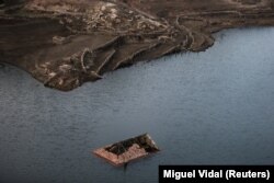 Kulmi i një shtëpie të përmbytur duket mbi ujë, teksa thatësira po rishfaq fshatin e zhdukur të Aseredos. Fotografi e shkrepur më 10 shkurt 2022.